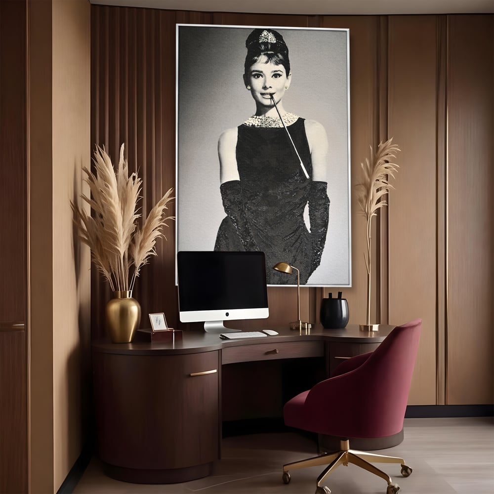 Tablou canvas cu tablou portret audrey hepburn cu tigara, in rama de aluminiu argintiu, pe perete intr-un birou